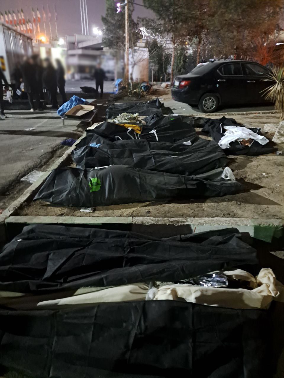 Covered bodies of protesters lying on the ground after clashes with Iranian security forces